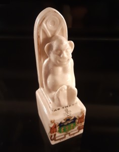 Sheffield crested china figure depicting Billiken. Similar good luck charms include Fumsup (Touch Wood) and the Lincolnshire Imp.